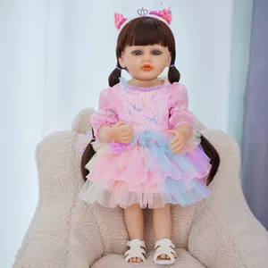 Detail view of 22-inch reborn baby doll in pink frilly dress with cute cat ear headband.