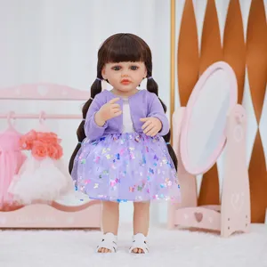 Detailed view of a 22-inch reborn baby doll with brown pigtails wearing a purple butterfly dress.