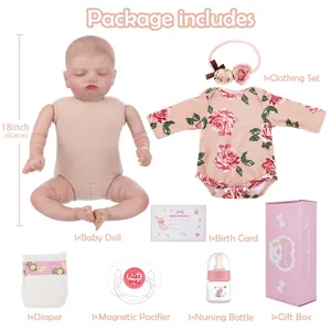 Reborn baby doll set detail view showing soft vinyl body, floral clothing, accessories and gift box.