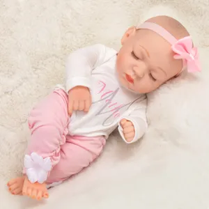 Detailansicht einer süßen Reborn Babypuppe in rosa Outfit mit Schleife auf weißem Fell.