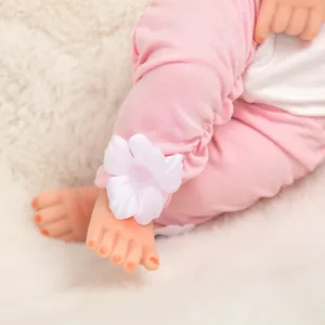 Detailaufnahme von rosa Puppenhose mit weißer Blume, weiches Zubehör für Puppen.