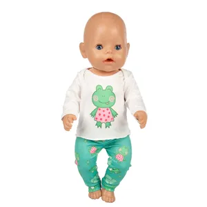 Puppenkleidung Detailansicht, süßes Cartoon Frosch Motiv weißes Langarmshirt und grüne Hose.