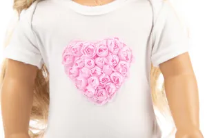 Detailansicht des weißen T-Shirts für 18-Zoll-Puppen mit rosafarbenem Rosen-Herz-Design.