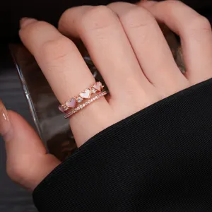 Close-up of double layer heart ring with zirconia and mother-of-pearl details on hand.
