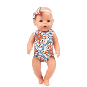 Detailed view of 43cm baby doll wearing stylish patterned romper and matching headband.