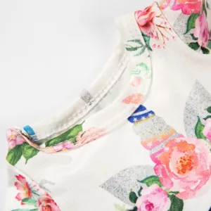 Nahaufnahme Detail des Blumen- und Einhornhorn Muster Puppenkleids aus weichem Stoff.