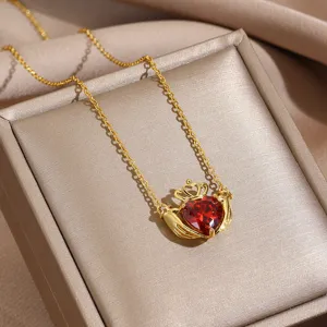 Stunning close-up of gold Claddagh necklace featuring a red heart crystal pendant.