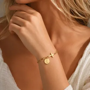 Braccialetto con iniziale dorata con ciondolo a croce e disco con lettera C per donna elegante.