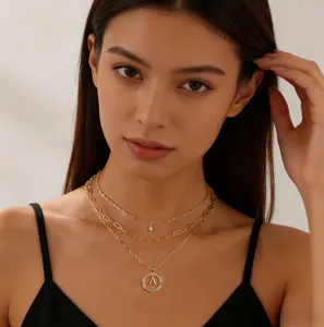 Collana multistrato dorata con ciondolo a bussola e lettera A brillante per donna chic.