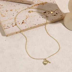 Detail shot of a delicate gold heart lock necklace with letter A pendant and sparkling rhinestones.