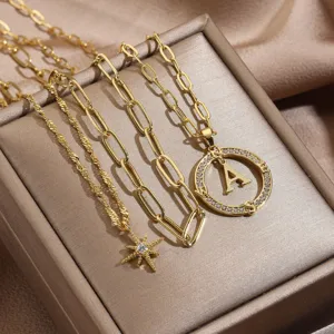 Collana multistrato dorata con ciondolo lettera A e stella per donna, primo piano dettagliato
