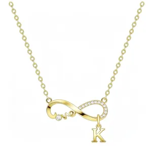 Dettaglio di una collana infinity dorata minimalista con ciondolo a forma di lettera K.