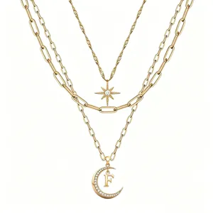 Detailed look at the multi-layer gold necklace with star and crescent moon letter F pendant.
