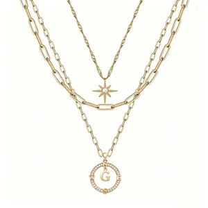 Collana multistrato dorata con ciondolo bussola lettera e dettaglio stella cristallo.