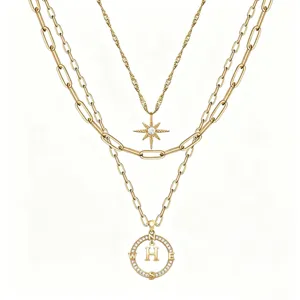 Collana multistrato vintage dorata con stella a sei punte e ciondolo a bussola con lettera.