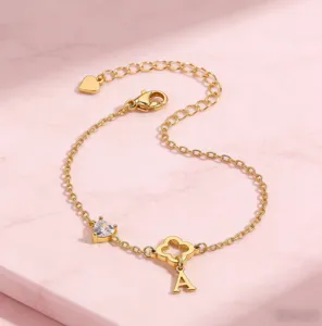 Detailansicht des vergoldeten Kleeblatt Herz Kettenarmbands mit Buchstaben Anhänger elegant.