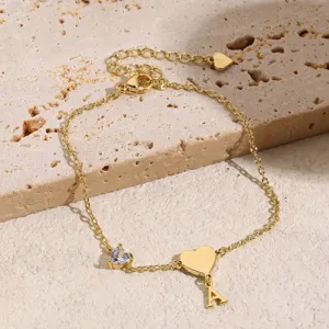 Bracciale dorato con lettera A, ciondolo a cuore e zircone, gioiello elegante da donna.
