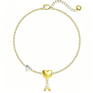 Dettaglio bracciale dorato con lettera A e ciondolo a cuore, gioiello elegante da donna.