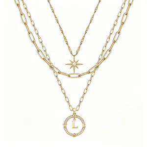 Set di collane d'oro multistrato con ciondolo a lettera bussola e stella a sei punte.
