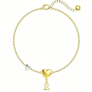 Dettaglio braccialetto con catena dorata con ciondolo a cuore e lettera E, gioiello.