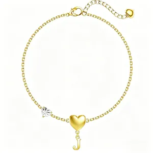 Dettaglio bracciale lettera J oro, catena maglie pendente cuore, elegante regalo donna.