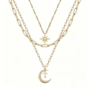 Multi-layer gold necklace featuring a star pendant and crescent moon with letter T detail.