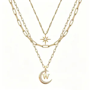 Close-up detail of the multi-layer gold necklace featuring star and letter W pendant.