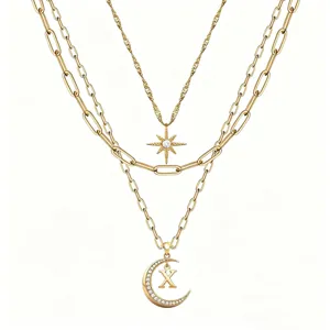Detail view of multi-layer layered gold necklace featuring rhinestone star and moon pendant.