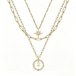Dettaglio collana multistrato dorata con ciondolo bussola lettera Z e ciondolo stella in cristallo.