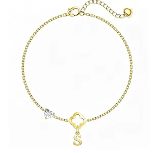 Nahaufnahme des goldenen Kettenarmbands mit Kleeblatt-Motiv, Herz-Anhänger und Buchstabe S.
