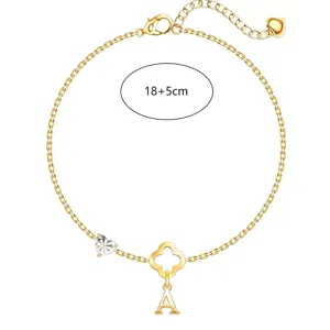 Detailaufnahme des goldenen Kleeblatt Armbands mit Buchstabe A Anhänger und funkelndem Herz.