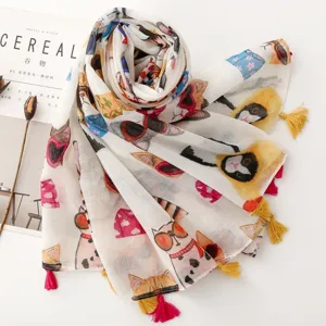 Gros plan d'un foulard imprimé de chats mignons avec des lunettes de soleil et des glands colorés.