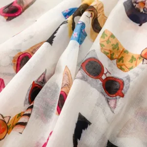Gros plan sur le tissu de l'écharpe imprimée de chats mignons, texture coton et lin douce.
