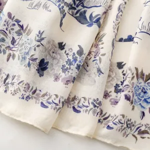 Close-up detail of soft floral printed scarf fabric showing elegant pastoral botanical art.