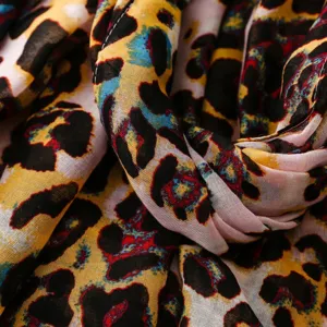 Gros plan detail foulard imprime leopard colore, texture tissu douce mode accessoire.