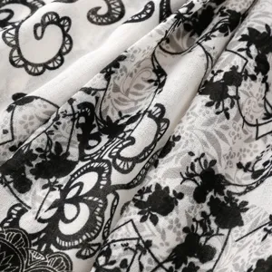 Close-up fabric texture detail of vintage black and white floral print long scarf shawl.
