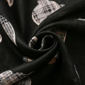 Primo piano dettagliato della texture del tessuto della sciarpa nera con motivo a quadri.