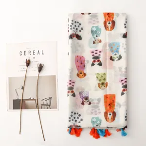 Vue detaillee d'un foulard femme en coton avec imprimé de chiens mignons et pompons.
