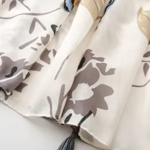 Primo piano dettagliato del tessuto della sciarpa floreale retro con nappe eleganti.