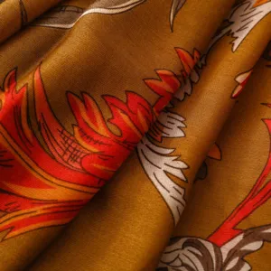 Detailed shot of retro printed silk scarf fabric, showing intricate red and gold floral pattern.