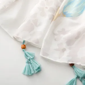 Primo piano dettaglio sciarpa donna retro floreale con ponpon perline protezione sole.