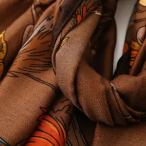 Close-up detail of vintage brown printed scarf showcasing fine fabric texture and artistic patterns.