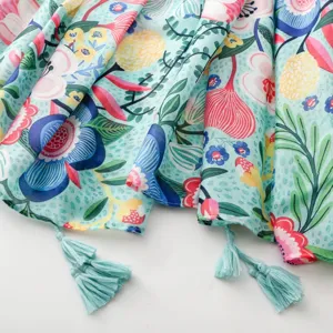 Gros plan du détail de l'écharpe florale ethnique, tissu doux avec motif floral coloré et pompons.