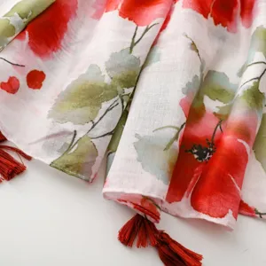 Détail d'écharpe à franges imprimé floral, tissu doux et couleurs vives pour un style élégant.