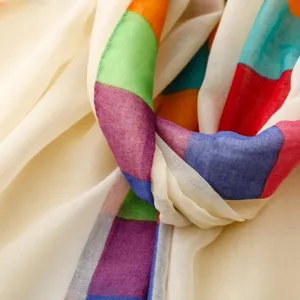 Gros plan de la bordure à carreaux colorés sur le tissu doux et léger du foulard.