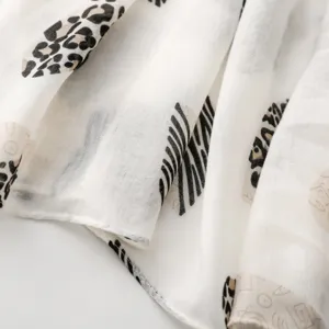 Detalle de bufanda con estampado animal ligero, tejido suave con leopardo y cebra.