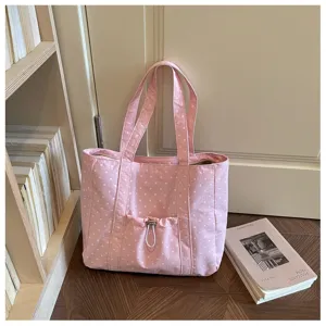 Borsa tote in tela a pois rosa vista in ambientazione, grande capacità con tasca frontale.