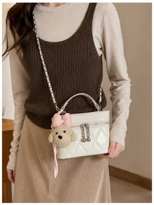 Vista detallada del bolso acolchado con cadena en color beige elegante con adorable perrito.