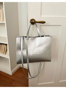 Bolso tote de piel sintética plateada colgado de la puerta, gran bolso de hombro.