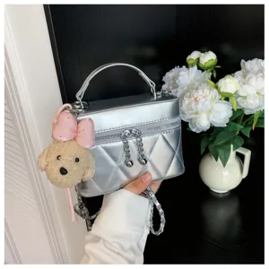 Bolso acolchado plateado con colgante de oso de peluche para un estilo otoñal chic.